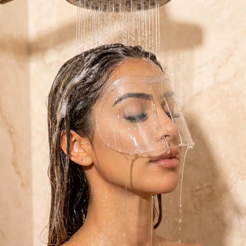 Woman in the shower wearing the clear Lashield visor over her eyes
